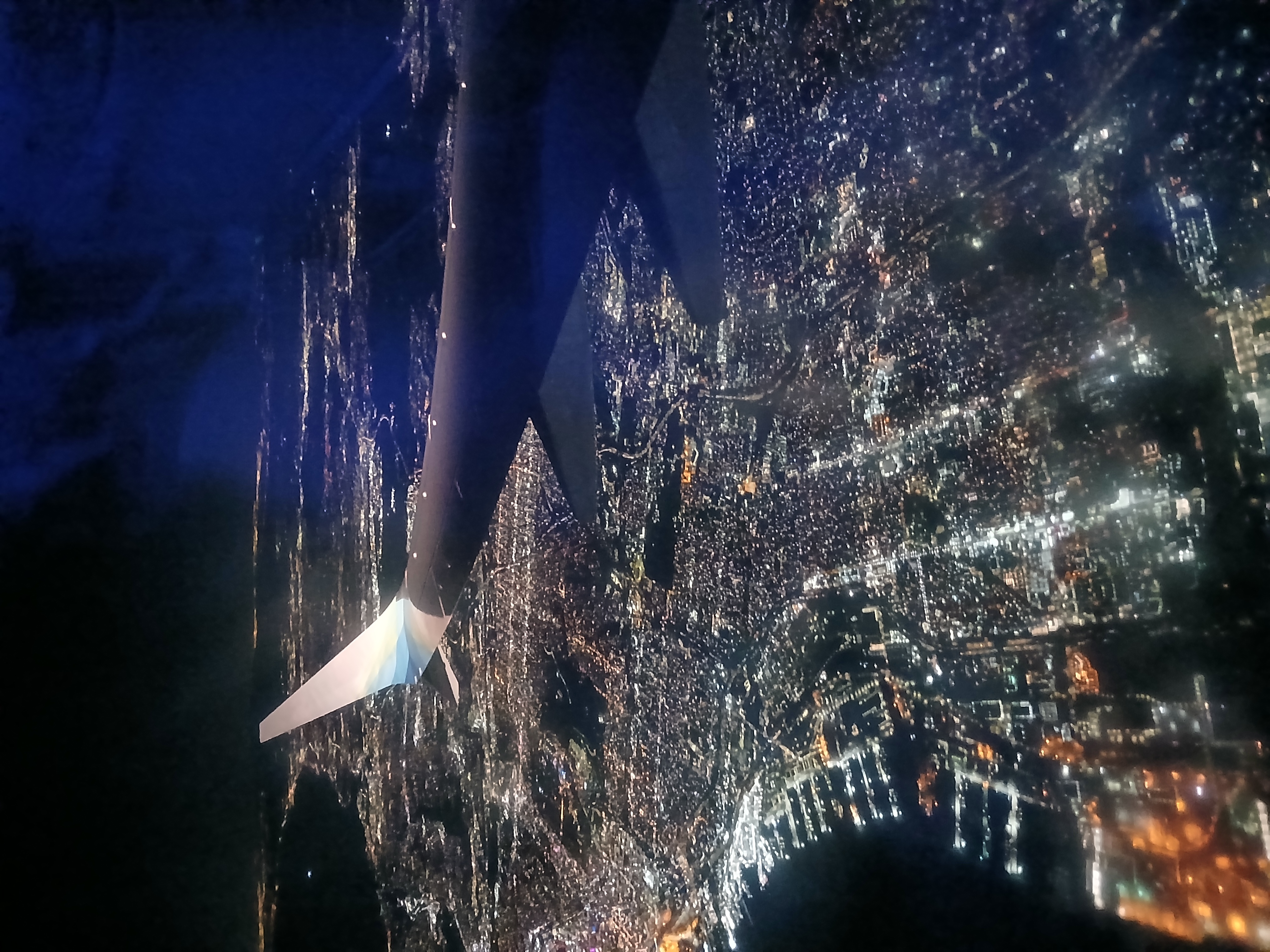 The wing of a passenger plane overlooking city lights as Chirstopher began his flight back to MCO from SAN.